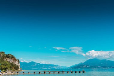Sirmione 'deki panoramik, arka planda dağlarla birlikte Lago di Garda' dan huzurlu bir manzara..