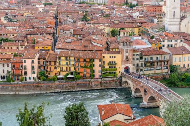 Verona Kalesi 'nin tepesinden yayılan panoramik, nehir boyunca uzanan ortaçağ şehrinin çatıları ve sokakları manzaralı..