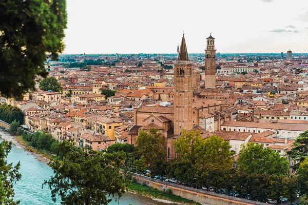 Verona Kalesi 'nin tepesinden yayılan panoramik, nehir boyunca uzanan ortaçağ şehrinin çatıları ve sokakları manzaralı..