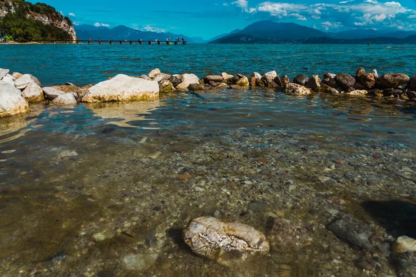 Rochas Molhadas Com Vista Para Lago Garda Montanhas Alpinas Fundo — Fotografia de Stock