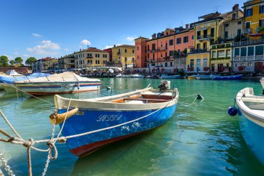 Peschiera di Garda, İtalya - 22 Ekim 2021: Kuzey Avrupa güneşini arayan tatilciler için Lago di Garda boyunca demirlemiş tekneler.