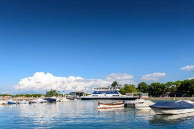 Peschiera di Garda, İtalya - 22 Ekim 2021: Kuzey Avrupa güneşini arayan tatilciler için Lago di Garda boyunca demirlemiş tekneler.