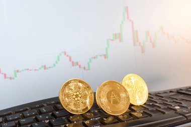 Cardano dijital para birimi, ADA, altın sikkeler, bir broker 'ın klavyesinde.