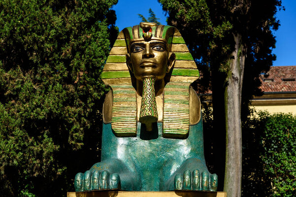 Peschiera di Garda, Italy - October 22, 2021: Imposing sculpture of a golden Egyptian sphinx exposed to the sun in a public park.