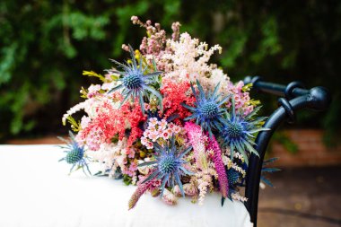 Düğün günü beyaz bir bankta uzanan güzel bir buket çiçek..