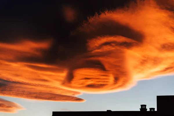 街の建物の後ろに赤とオレンジの雲と美しい夕日の空 — ストック写真