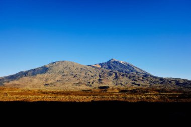 Teide yanardağının güzel panoramik görüntüsü. Yoğun mavi gökyüzü ile güneşli bir gün. Doğa turistleri tarafından eğlendirilecek..