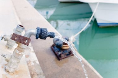 Limandaki servis musluğundan denize su dökülüyor..