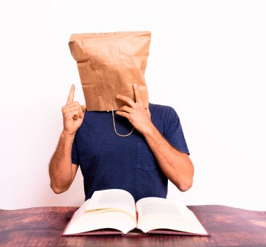 Kafası kağıt torbayla kaplanmış, elleriyle hareket eden komik bir adam..