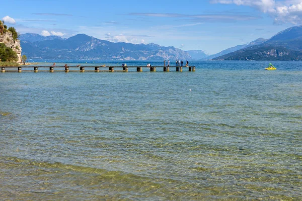 Sirmione 'deki panoramik, arka planda dağlarla birlikte Lago di Garda' dan huzurlu bir manzara..
