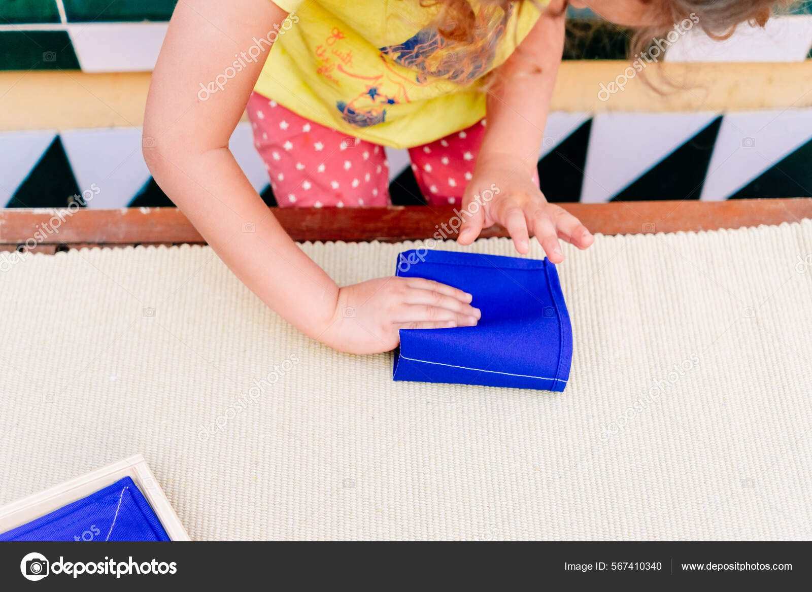 为孩子们折叠餐巾纸是提高蒙台梭利学校学生手部运动技巧的一项任务 图库照片 C Joaquincorbalan