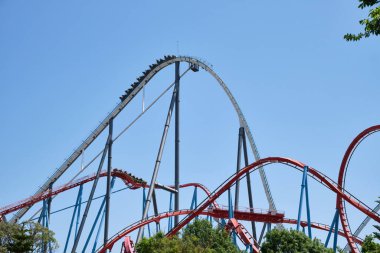 Valencia, İspanya - 20 Mayıs 2022: Uzun, ince bir metal yapı güneşli bir yaz gününde eğlenceli bir hız trenini destekler..