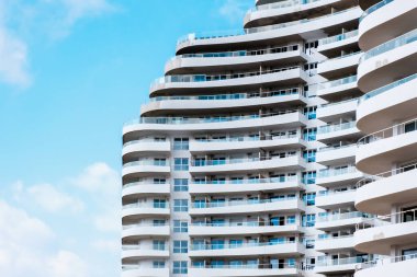 Terasları ve balkonları olan beyaz bir binanın geniş cephesinin ayrıntıları..