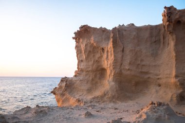 Erozyondan kaynaklanan kireçtaşı kayalıkları beyaz kumsala dönüşür..