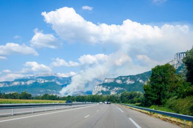 Smoke from a forest fire on a mountainside in Voreppe, France during summer day.