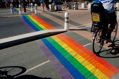 Geneva, Switzerland - August 25, 2022: Pedestrian crossings with the gay pride rainbow flag on the streets of a populous city.