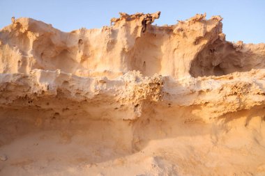 Rüzgarla aşınmış kumlu bir arazinin detayları ve kıyıya yakın dalgalar..