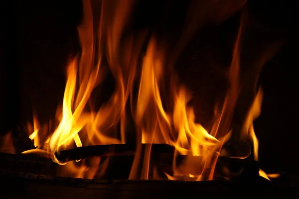 Feuer im Kamin, Flammen auf schwarzem Hintergrund Stockbild