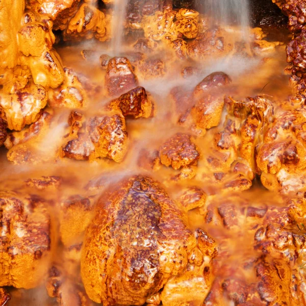 Vodopád, padající na oranžové a zlaté kameny — Stock fotografie