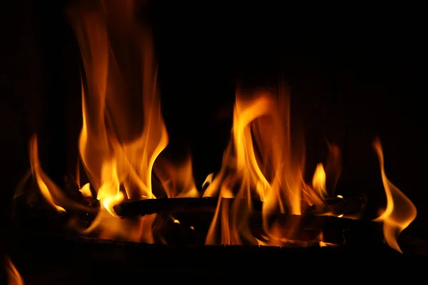 Feu dans une cheminée, flammes de feu sur un fond noir — Photo