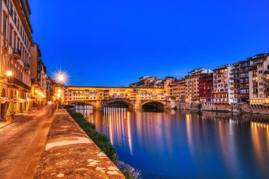 Ponte Vecchio Köprüsü 'nü Dusk, Floransa, İtalya' daki Arno Nehri Yansıması ile aydınlatmış. 