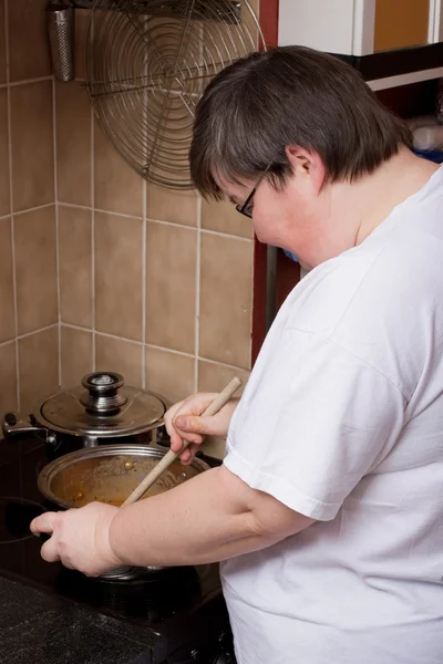 Mentally disabled woman is cooking — Photo