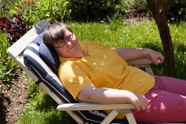 Disabled woman basks in a deck chair — Stock Photo, Image