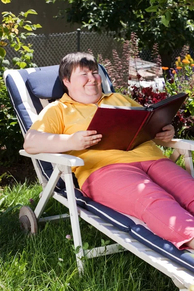 Disabled woman reading a book in the garden — Fotografia de Stock