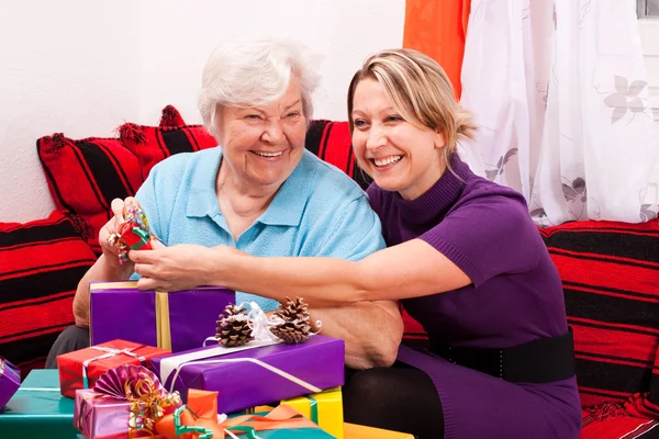 Female senior with young woman and gifts — Stock Photo, Image