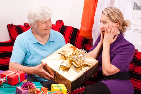 Senior gives gift to young pretty woman — Foto Stock