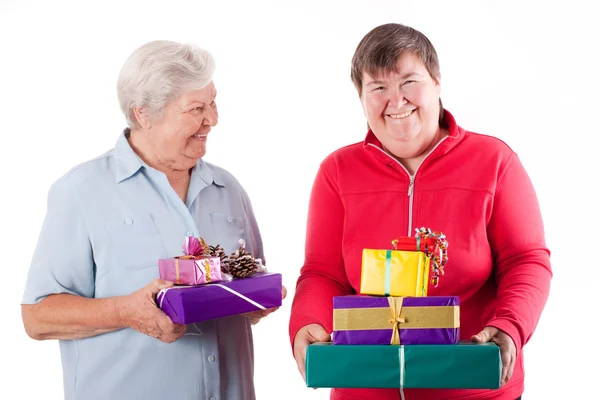Female senior and mental disabled woman holding gifts — Stock Photo, Image