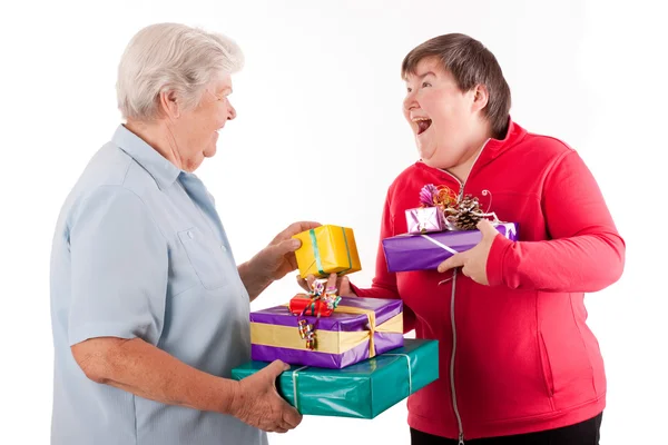 Senior and mental disabled woman holding presents — Stock Photo, Image
