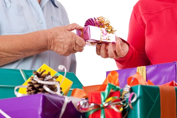 Senior and daughter reaching gift to each other — Stock Photo, Image