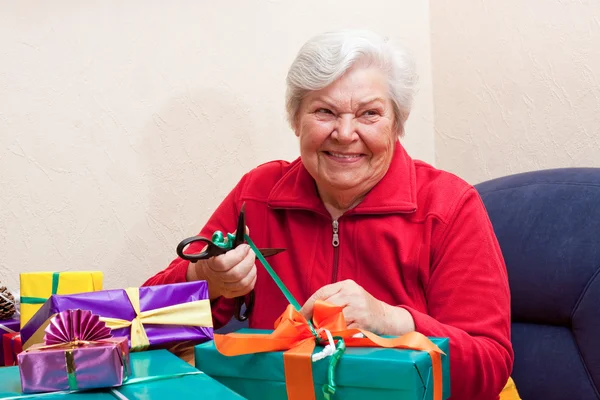 Female senior pack or unpack an gift — Zdjęcie stockowe