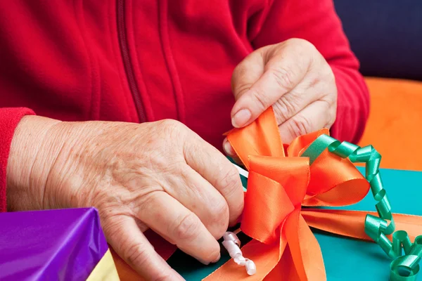 Senior citizen wrap or unpack gifts, closeup — стоковое фото