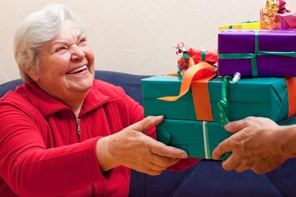 Female Senior sits and gets or give many presents — Foto Stock