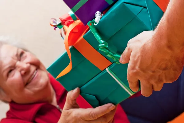 Senior sits and gets or give many presents closeup — Stock Photo, Image