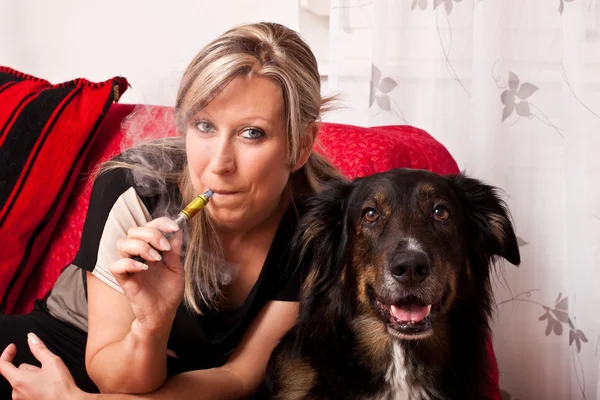 Blonde woman with dog and electric cigarette — Stock Photo, Image