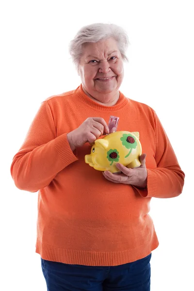 Friendly senior holding a piggybank — 스톡 사진