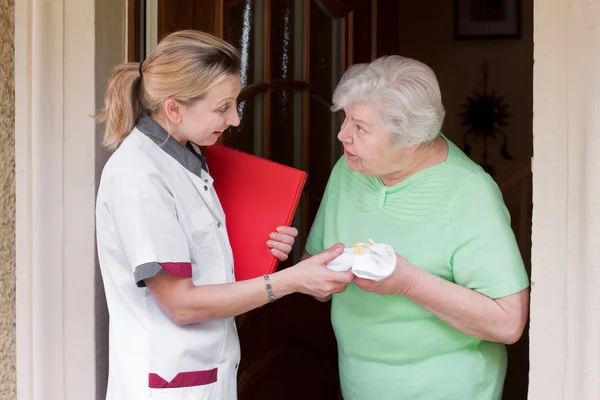 Nurse visiting a patient at home — Stockfoto