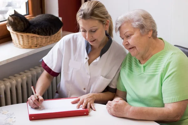 Nurse visiting a patient at home — Stock Photo, Image