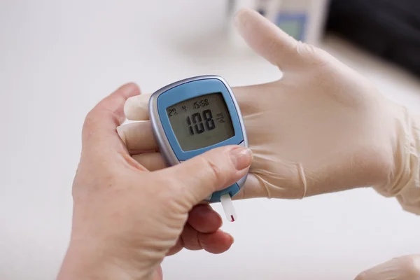 Geriatric nurse measures the glucose level — ストック写真