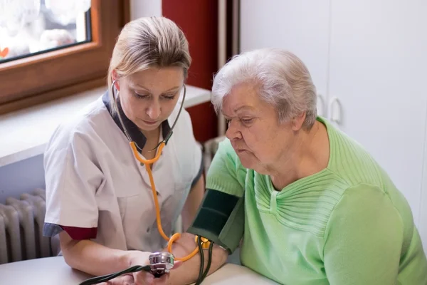 Nurse measures blood pressure of an patient — 图库照片