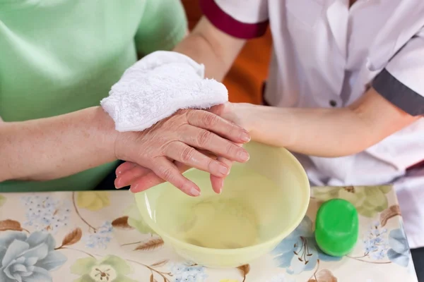 Nurse washes old patient's hands — Photo