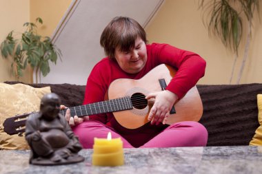 Disabled woman plays guitar and is happy