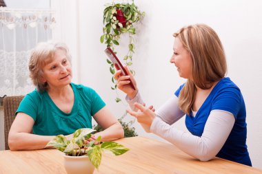 young woman showing Senior a comb