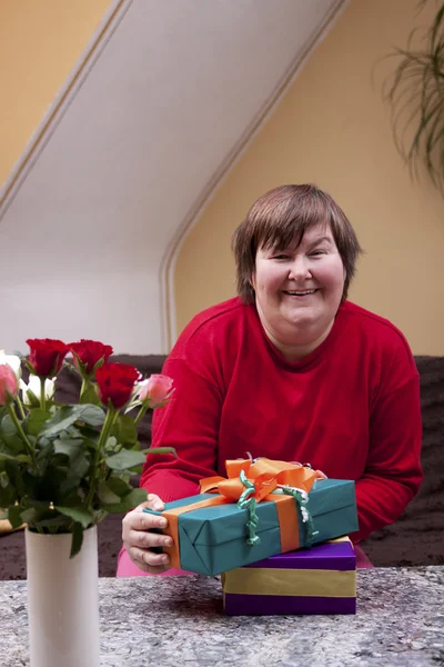 Mentally disabled woman holding many gifts — Stockfoto