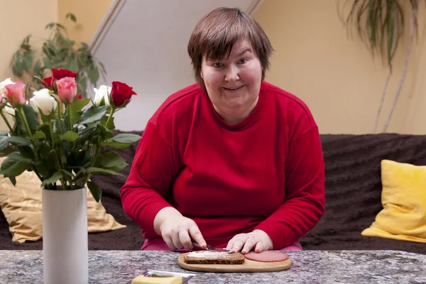 Mentally disabled woman is making up a sandwich — Stock Photo, Image