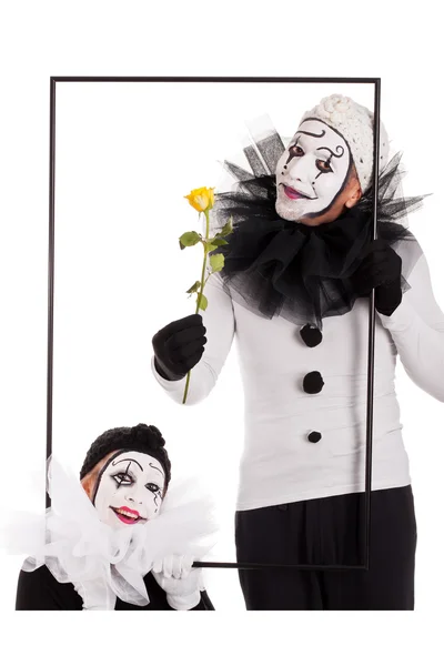 Two clowns in a frame with a yellow flower — стоковое фото