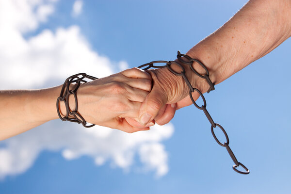 Two woman hands are chained together
